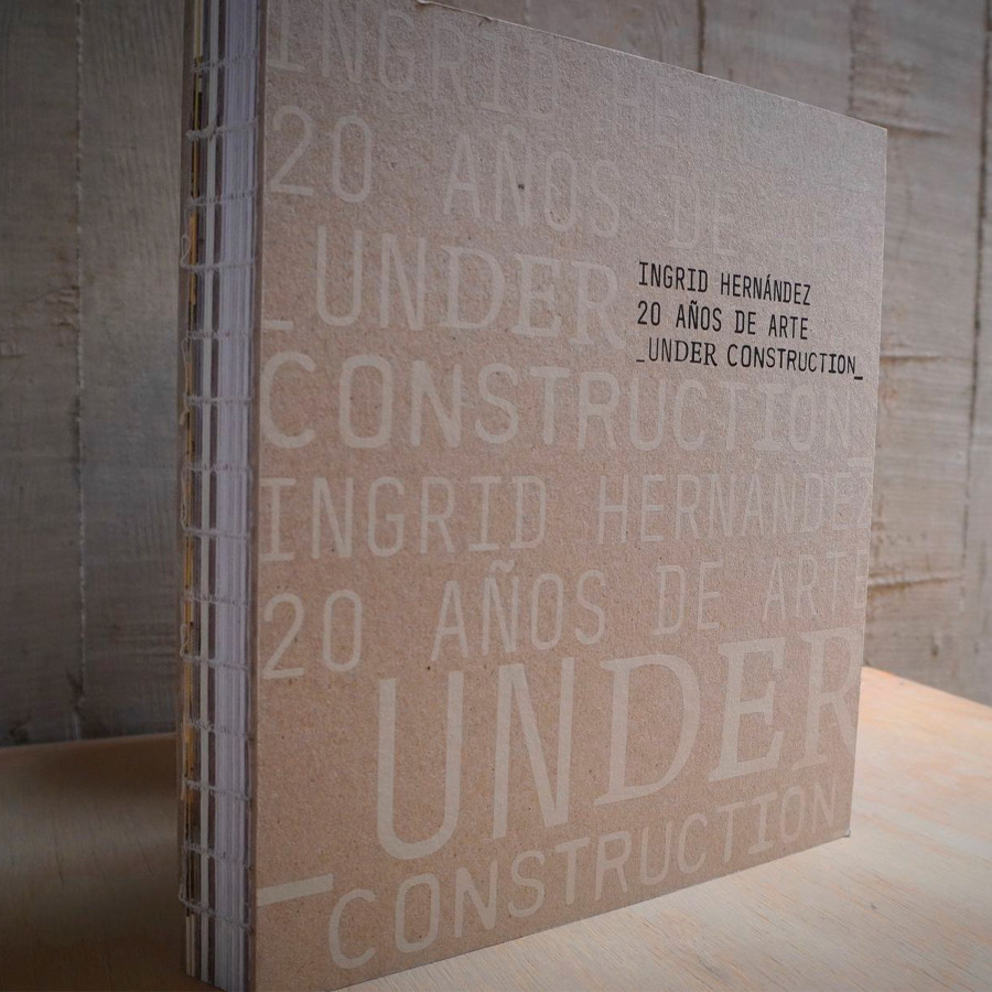 Portada del catálogo Ingrid Hernández. 20 años de arte _Under Construction_, de encuadernación cosida a la vista y cubierta de cartón con el título tipografiado en blanco.